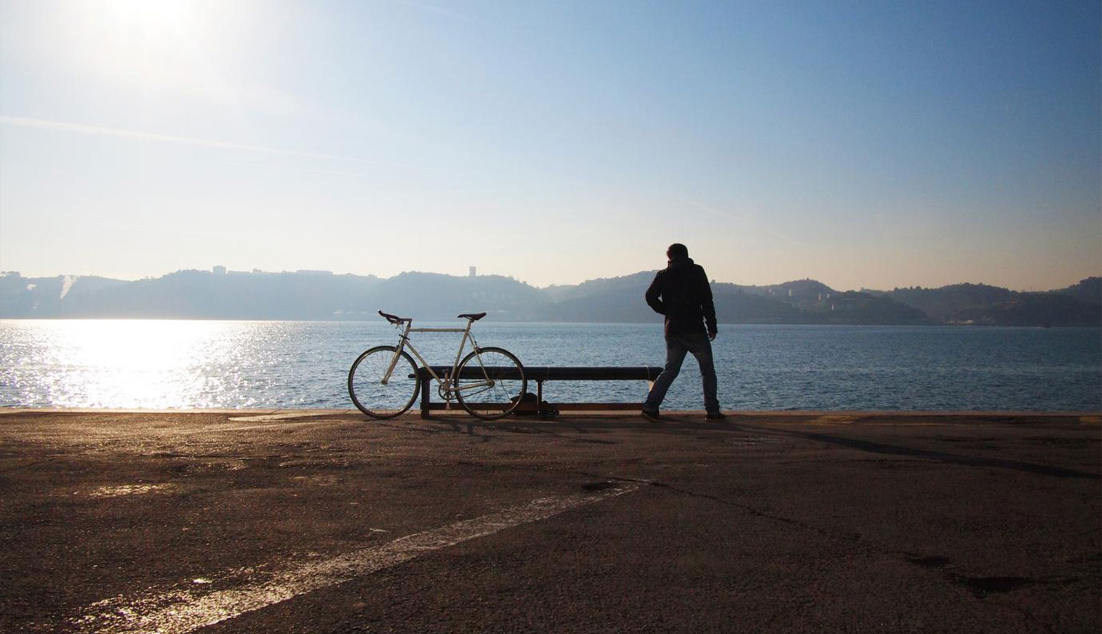 A man standing next to a bench with a bike on it.